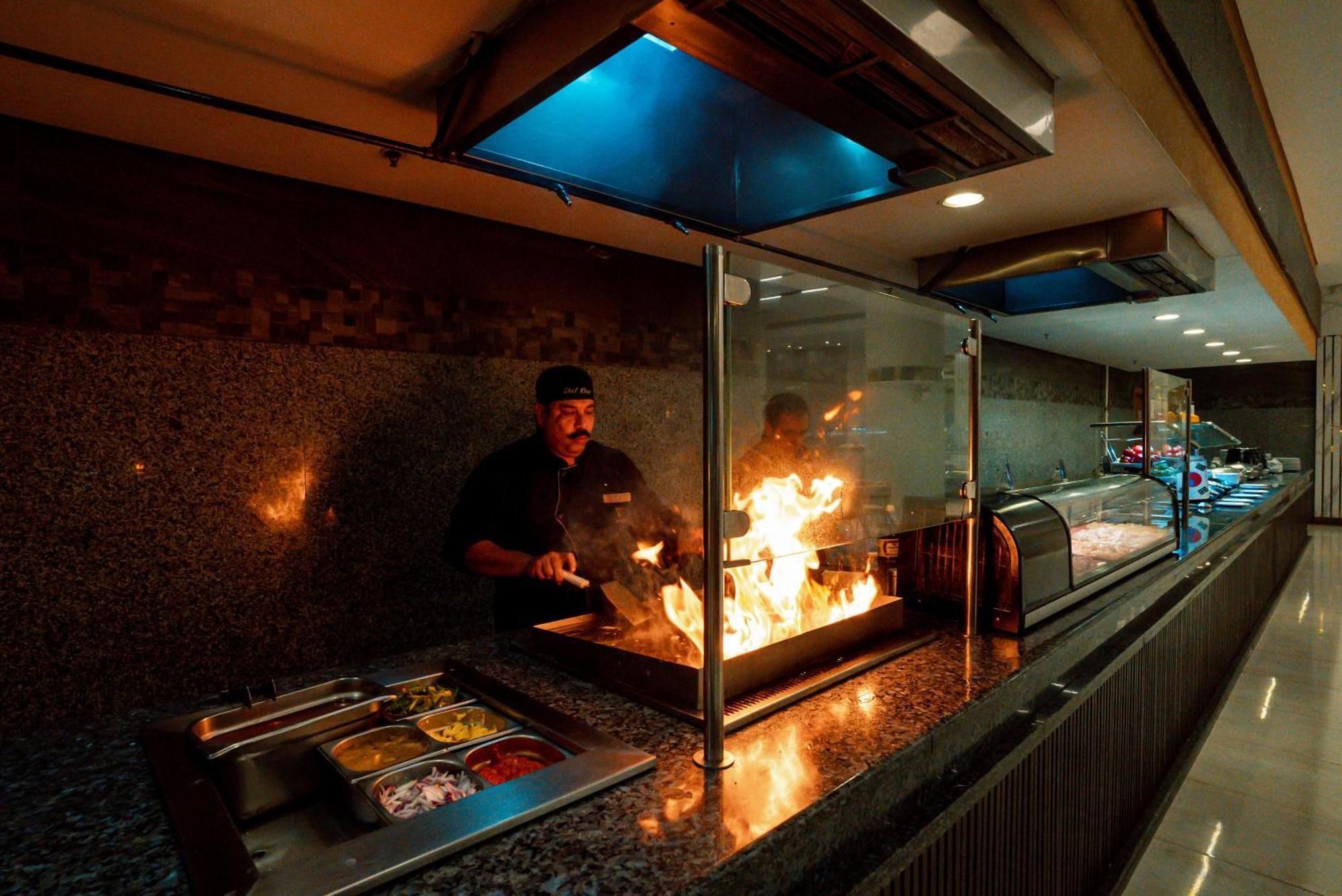 The V Luxury Resort Sahl Hasheesh Hurghada Extérieur photo A chef cooking with a flaming torch