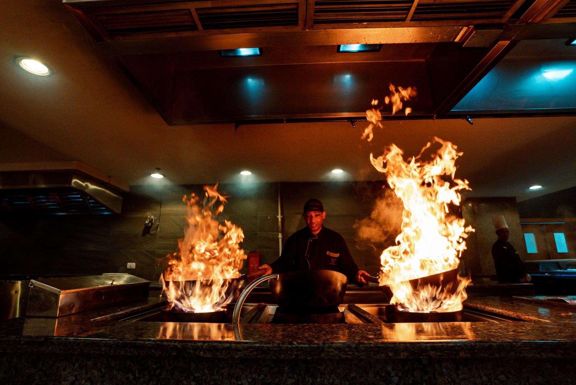 The V Luxury Resort Sahl Hasheesh Hurghada Extérieur photo A chef cooking with a wok