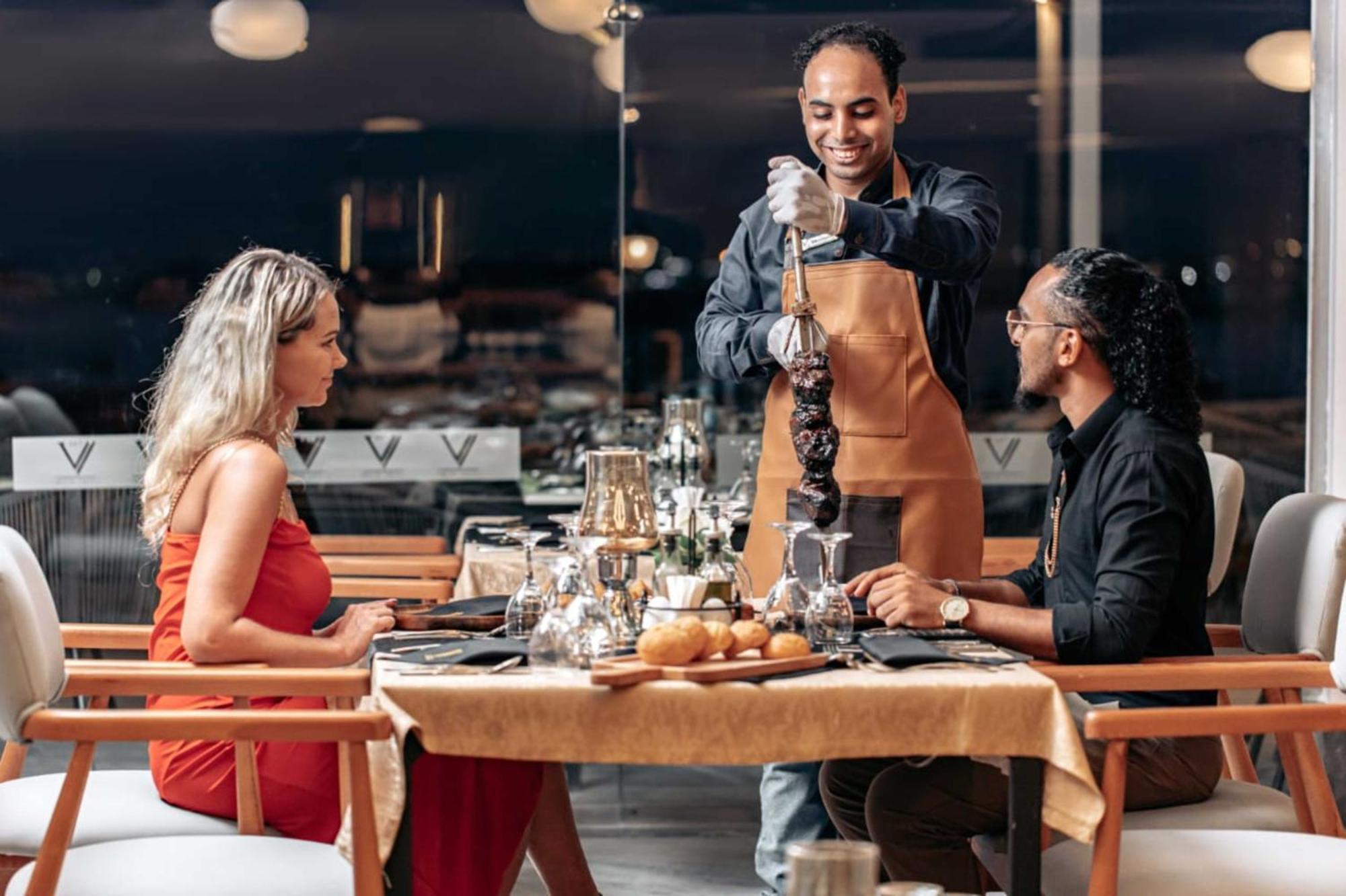 The V Luxury Resort Sahl Hasheesh Hurghada Extérieur photo A waiter serving a couple at a restaurant